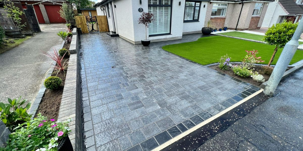 Charcoal block-paved front driveway with kerb edging running up to a modern UK home